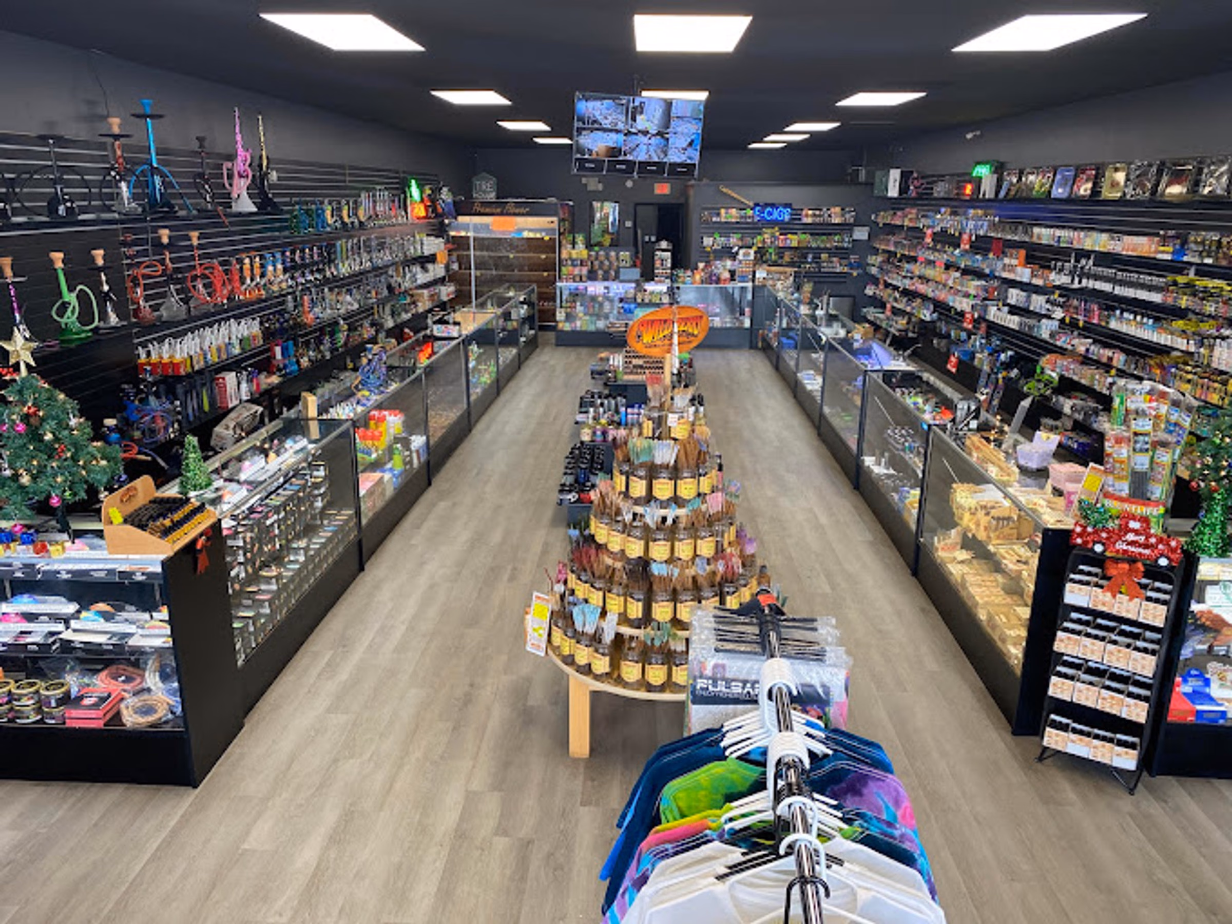 Wide view of the sales floor at Metro Smoke Shop, Mount Dora, with hookahs on the left wall and accessory cases either side